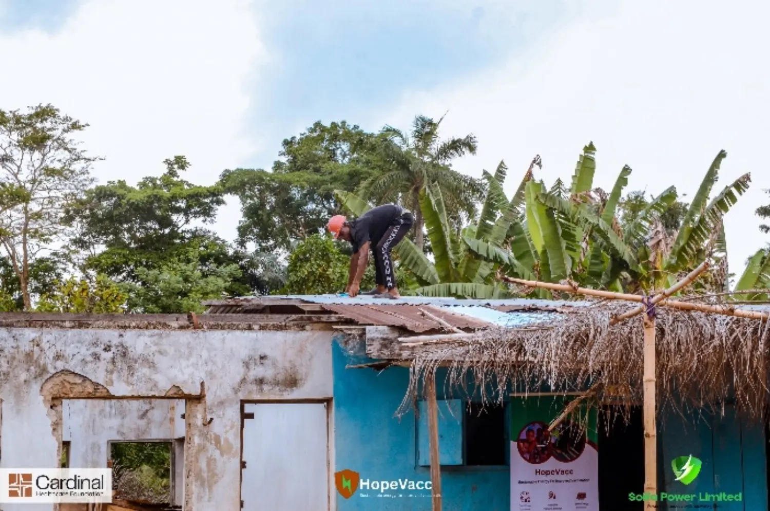 Solfa Power team installing rooftop solar panels on a hospitality building beneath palm trees and a clear blue sky
